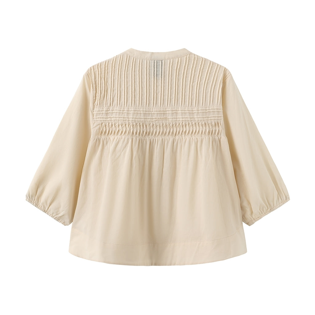 Beige Luxzuz Percha-bluse med plisseret, rynket øvre rygparti og lange ærmer, vist på en ensfarvet baggrund.