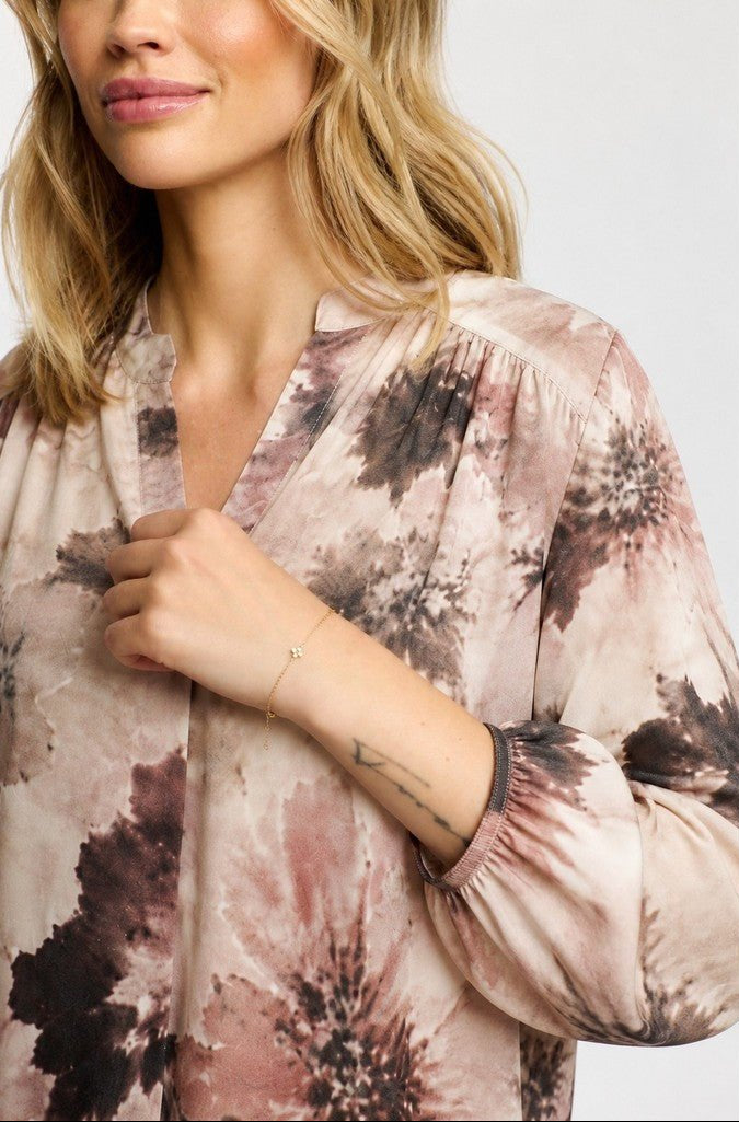 Kvinde i 2-Biz – Bluse med Eve Brun-mønster med abstrakt blomsterprint og en tatovering på hvid baggrund.