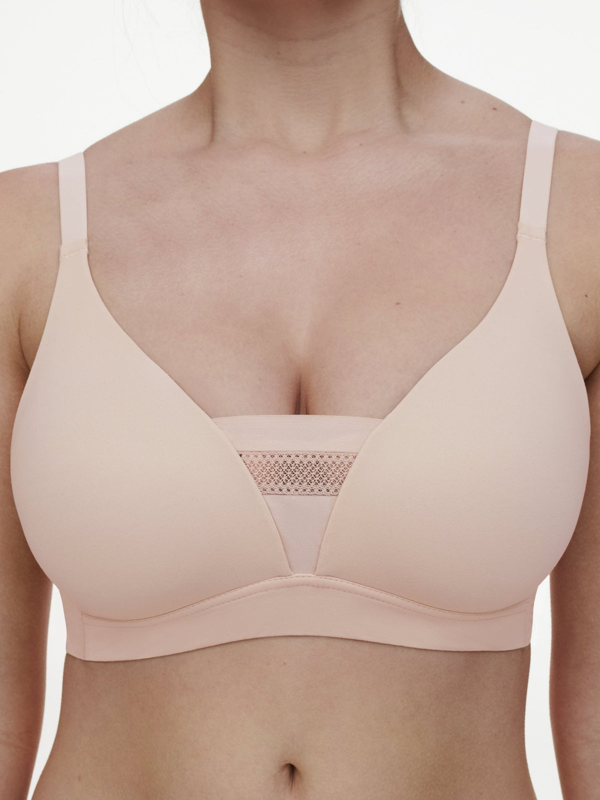 En kvinde har Chantelle EasyFeel 152526 Easy Bliss-bhen på i farven Golden Beige Pudder med et netindsats i midten.