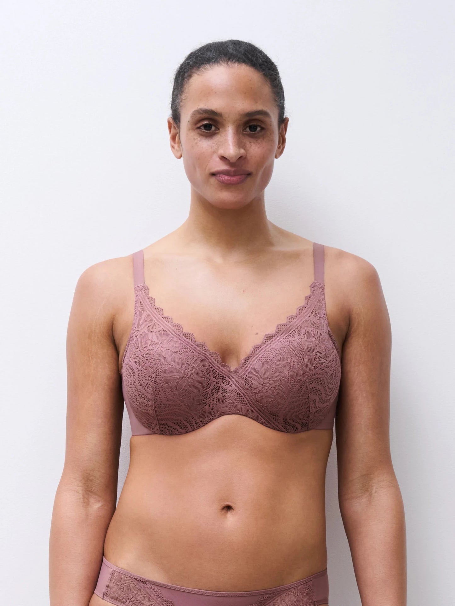 Modellen bærer et Chantelle EasyFeel Floral Touch Rose Des Bois Gammelrosa-sæt og står foran en ensfarvet baggrund med blikket rettet fremad.