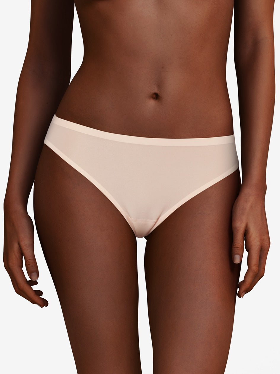 En model bærer Chantelle Seamless - Soft Stretch String Sand 130753 undertøj med et sømløst design på en ensfarvet baggrund.