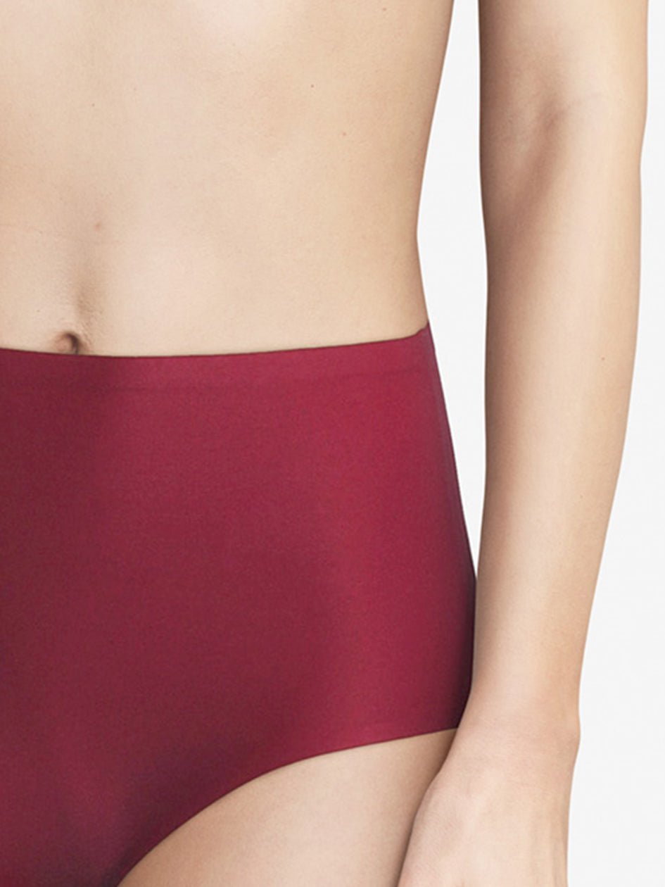 Modellen bærer Chantelle Seamless - Soft Stretch Maxi Mørkerød trusse, som ses fra midten af overkroppen til låret på en ensfarvet baggrund.