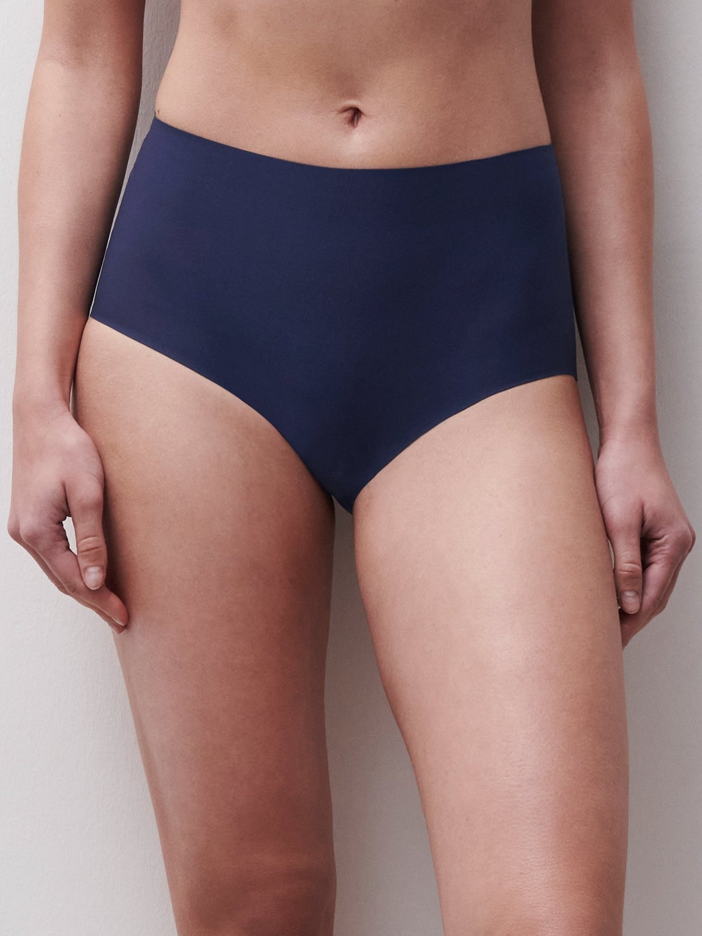 Modellen i Chantelle Seamless Soft Stretch Maxi i mørkeblå står foran en ensfarvet, lys baggrund.