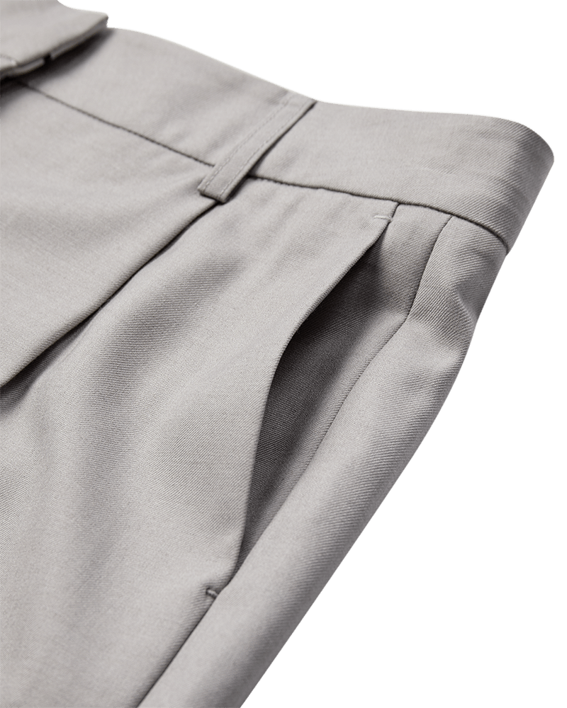 Nærbillede af lommen, linningen, sømmene og bæltestropperne på Copenhagen Muse Tenna Lysegrå-culotte-shorts på hvid baggrund.