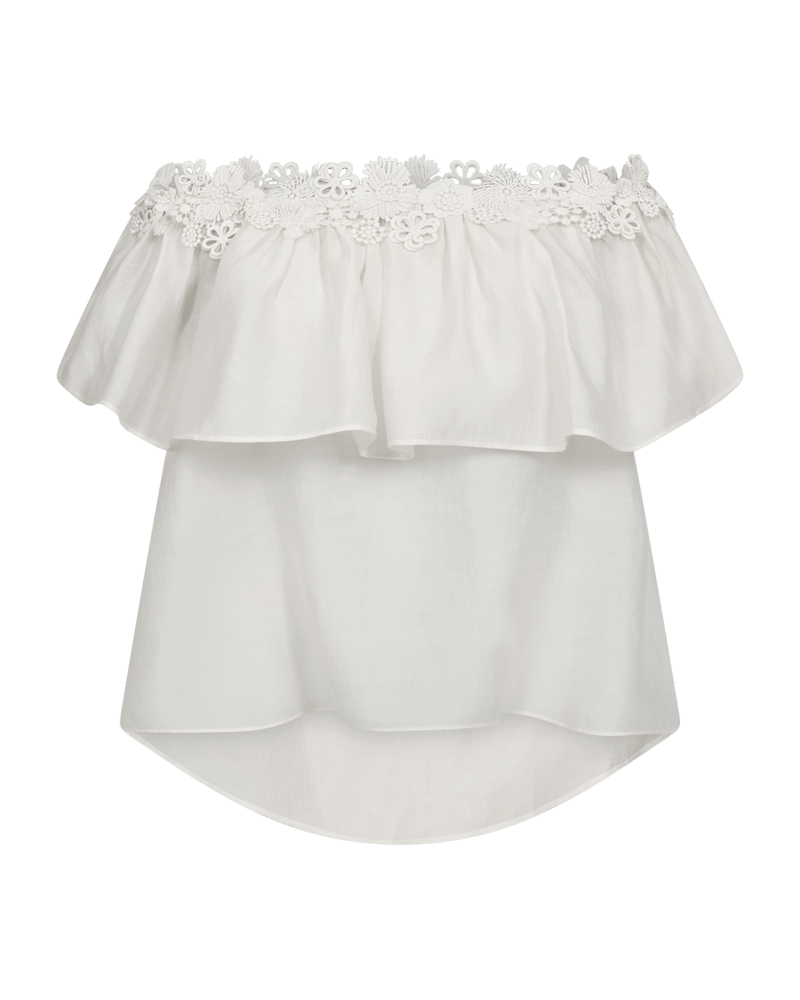 Copenhagen Muse Molly: Off-white lyocell-bluse med blomsterblonder ved halsudskæringen, lag med flæser og asymmetrisk nederkant.
