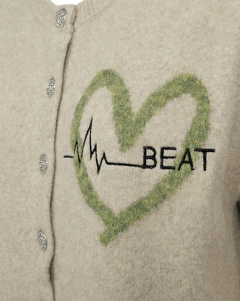 Nærbillede af Freequent Nomas Beige-vest med sølvknapper, en grøn hjerteomrids, en EKG-kurve og teksten »BEAT« på forsiden.