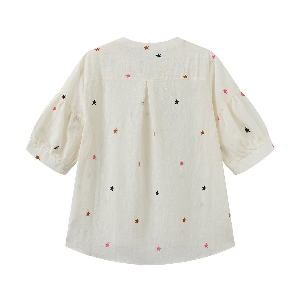 Luxzuz Vibse-bluse i offwhite med broderede stjerner, vist bagfra mod en enkel baggrund.