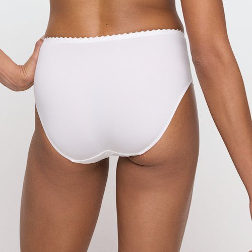 Modellen bærer Marie Jo – Jane Natural Off-white maxitrusse, set bagfra, på en ensfarvet lys baggrund.