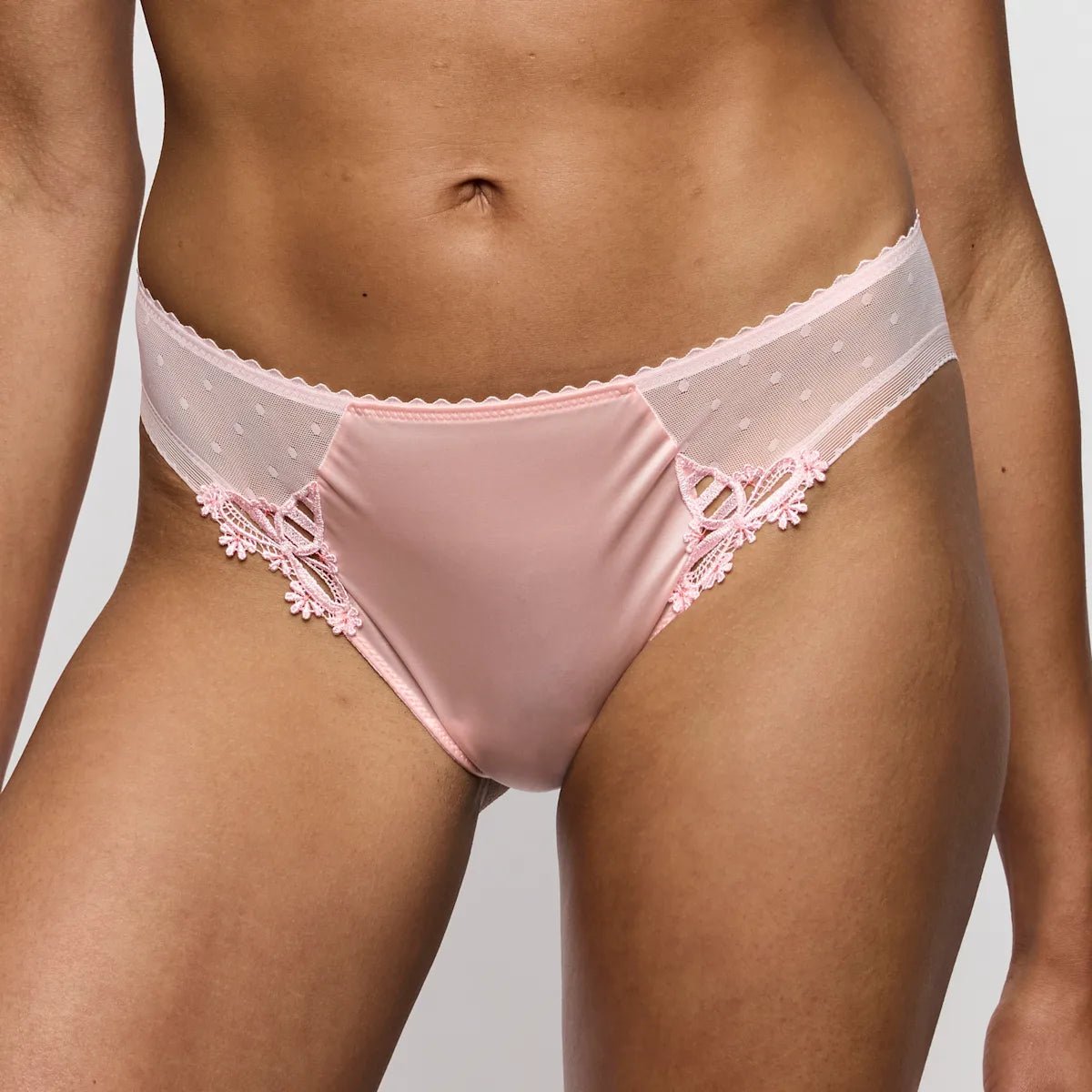 Modellen bærer Marie Jo – Noova Gardenia Rose Lyserød 154028, en lyserød bh i satin og blonder med mesh- og prikmønsterdetaljer.