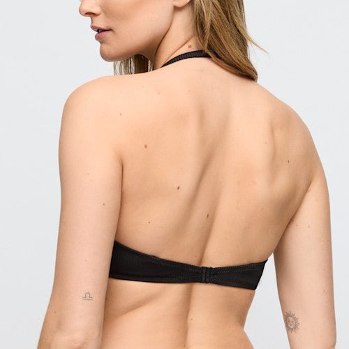 Kvinde set bagfra i en bikini-top fra Marie Jo Swim – modellen »Cassie Black Sort«, med tatoveringer på venstre arm og nederst på ryggen.