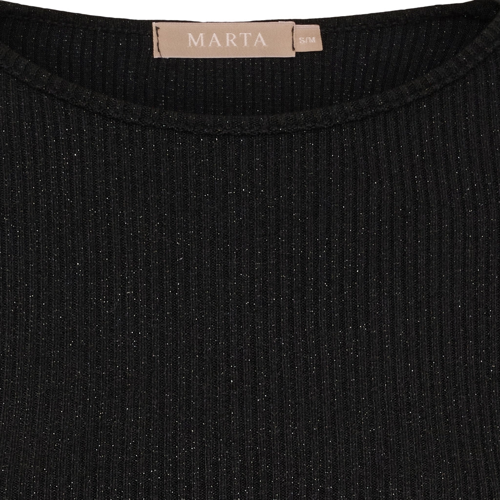 Nærbillede af en sort Marta du Château Lunara-bluse med diskret glitter og et beige MARTA S/M-mærke ved kraven.