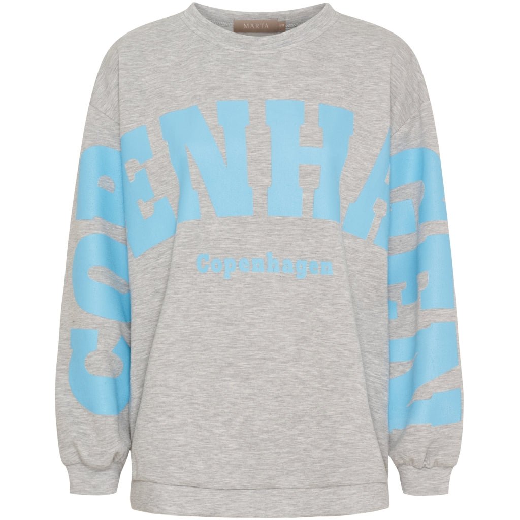 153762 Hibiscus Blå mønstret sweatshirt fra Marta du Château med lyseblå tekst på brystet og ærmerne.