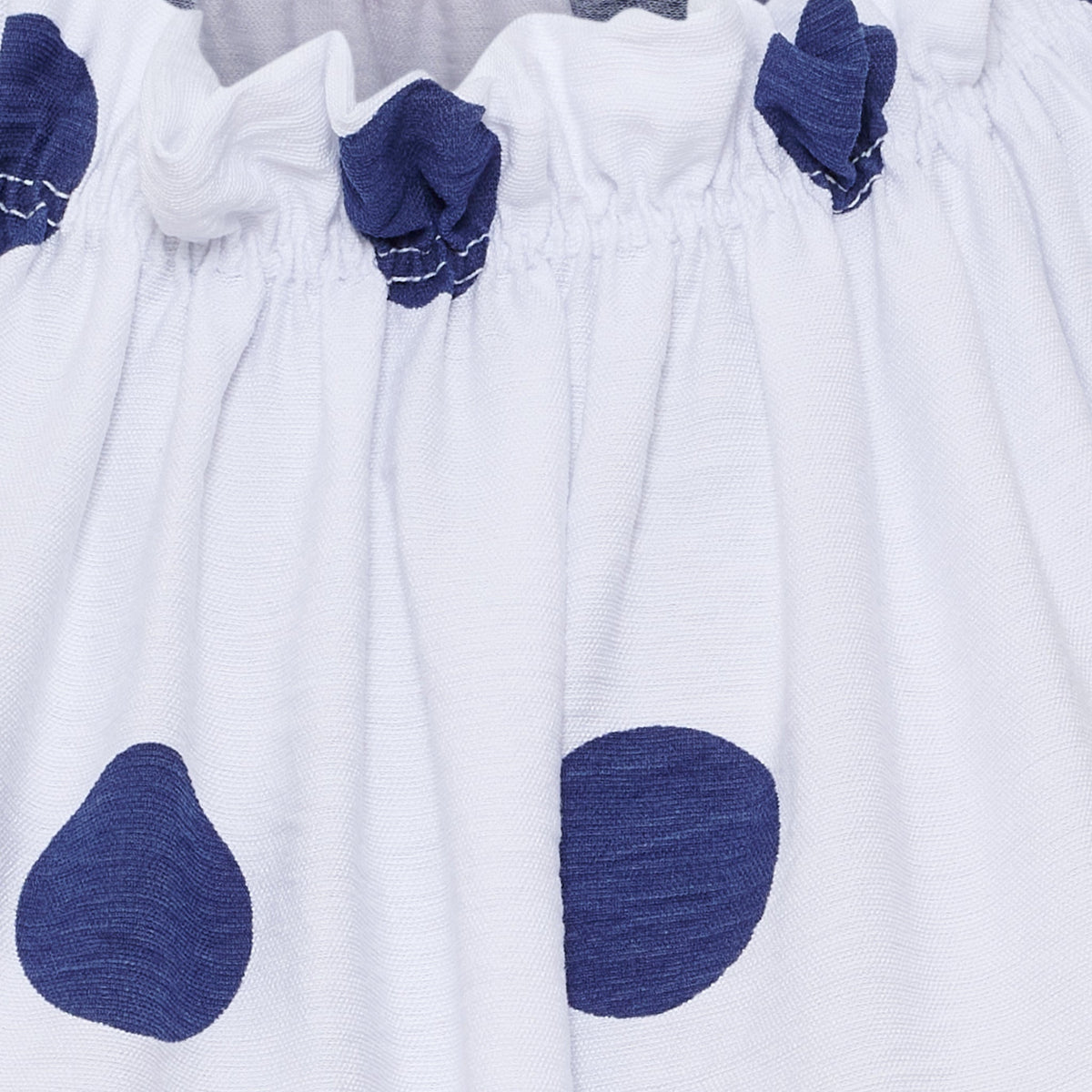 Hvid Lucina-bluse fra Marta du Château med marineblå prikker og elastisk kant; en sommerbluse, der er perfekt til varme dage.