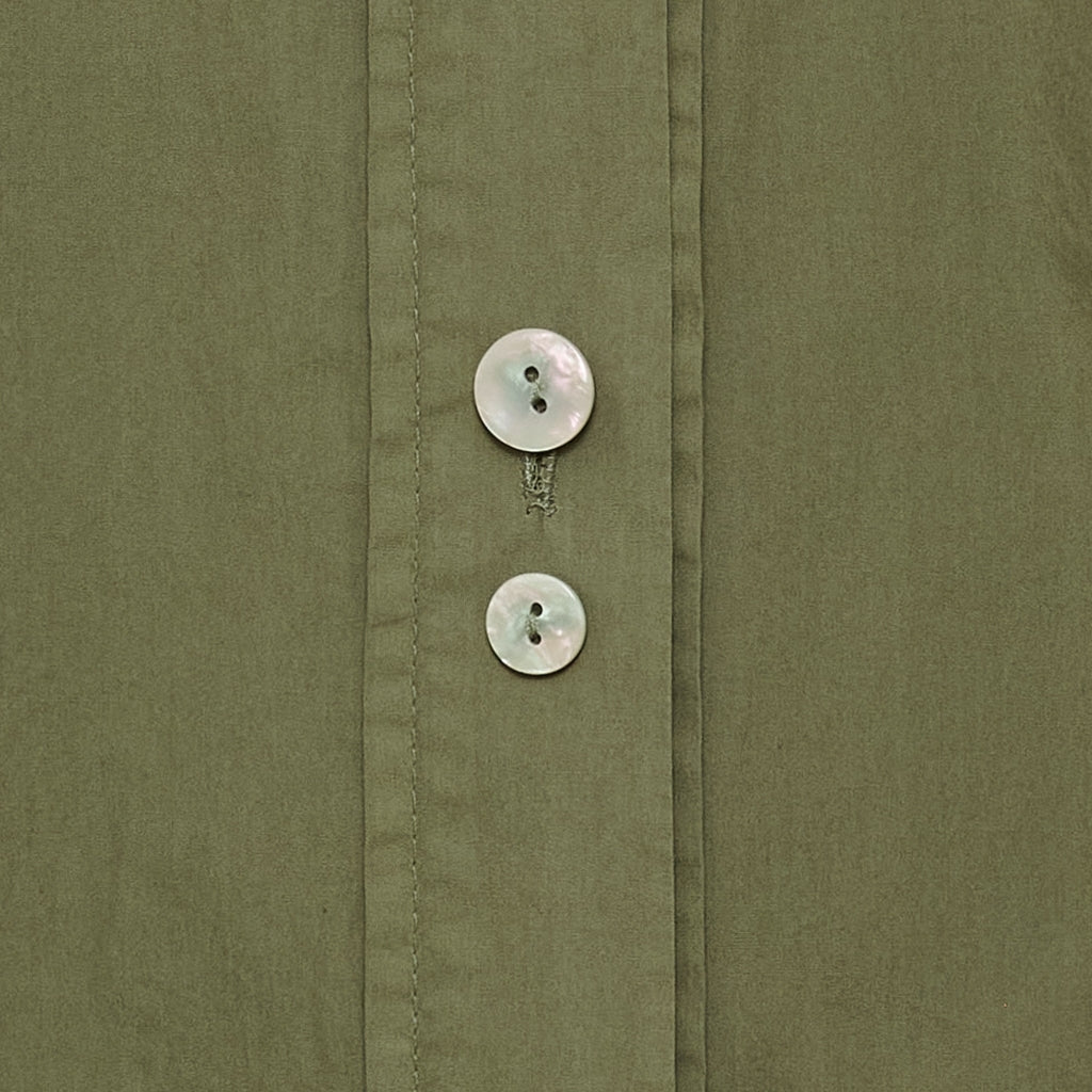 Nærbillede af to hvide knapper på Marta du Château’s Citrine Khaki, der fremhæver detaljen ved knaplukningen.