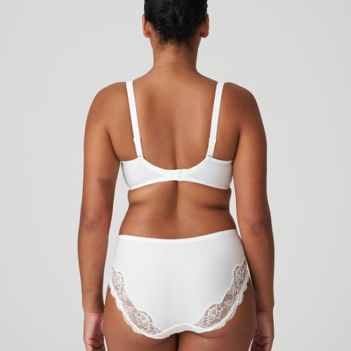 Person, der står med ryggen til, iført en PrimaDonna Madison Natur Off-white maxitrusse, foran en ensfarvet baggrund.