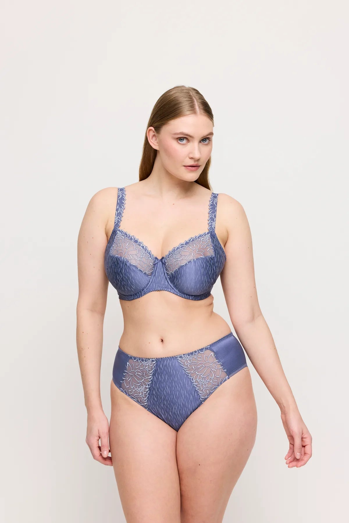Et sæt med bh og trusser fra PrimaDonna i modellen Monterrey i farven Nightshadow Blue med feminint blåt blonder, vist på en ensfarvet lys baggrund.