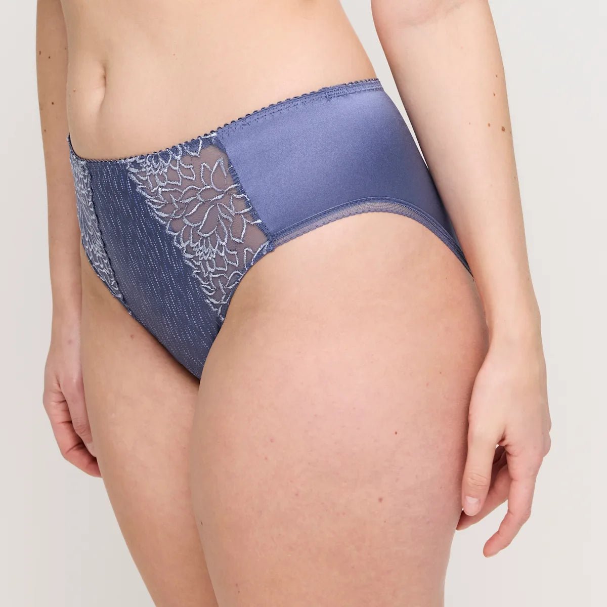 Iført PrimaDonnas »Monterrey Nightshadow Blue« fremviser denne person en elegant maxi-truss i blonder med blomsterbroderi.
