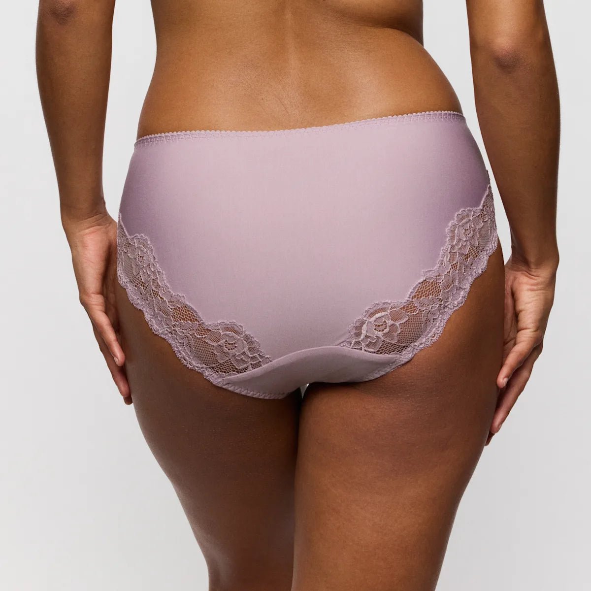 Model iført PrimaDonna Madison Soft Sand Lyng-maxi-trusser i mauveblond, set bagfra på en ensfarvet grå baggrund.