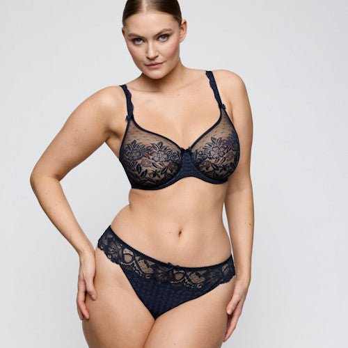 Modellen bærer PrimaDonna Madison Velvet Blue Mørkeblå undertøj og poserer selvsikkert med den ene hånd på hoften.
