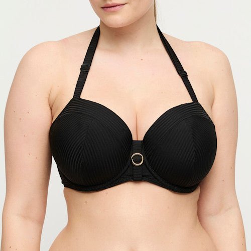Kvinden bærer PrimaDonna Swim Delray Black Sort, en sort bikini-top med halterneck og ringdetaljer fra PrimaDonna.