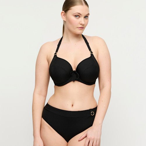 Kvinde iført PrimaDonna Swim – Delray Black Sort bikini og bikinibukser med høj talje fra PrimaDonna Swim på en ensfarvet lys baggrund.