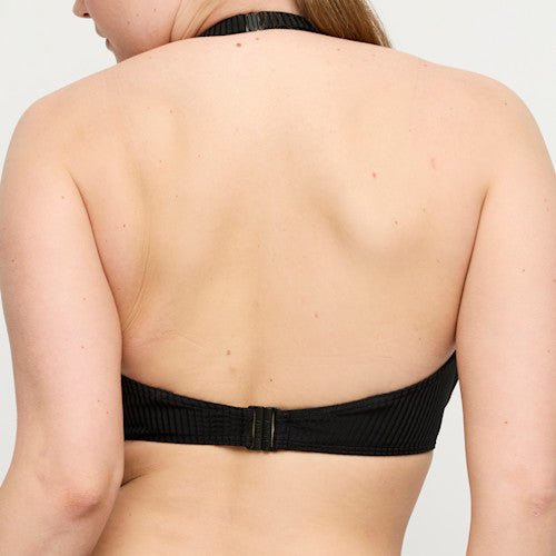 En person med langt hår viser PrimaDonna Swim 155258 Delray Black Sort bikini-overdragt, set bagfra.