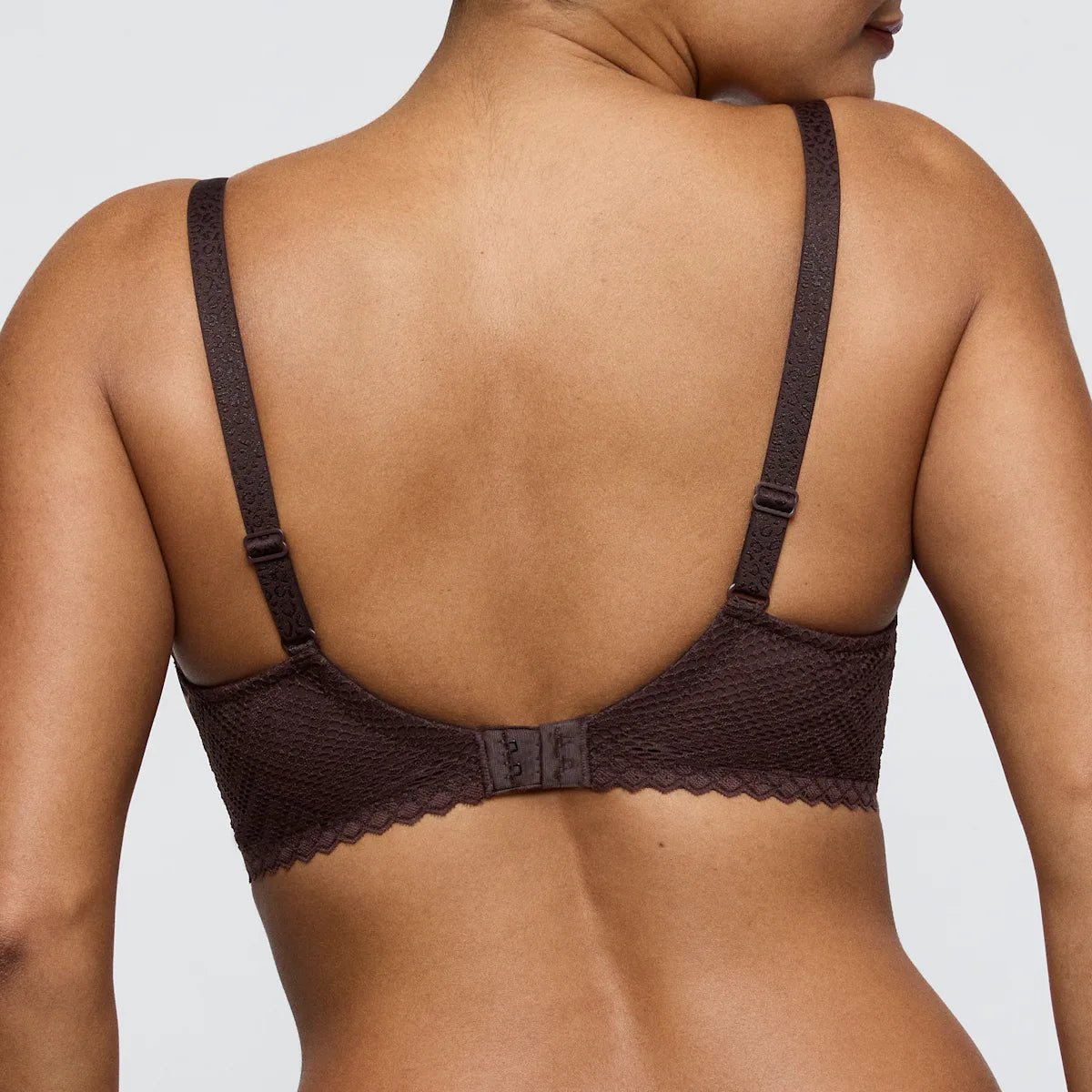 Model iført PrimaDonna Twist 155645 Giganni Leopard Bloom-bh, mørkebrun, set bagfra, med justerbare stropper.