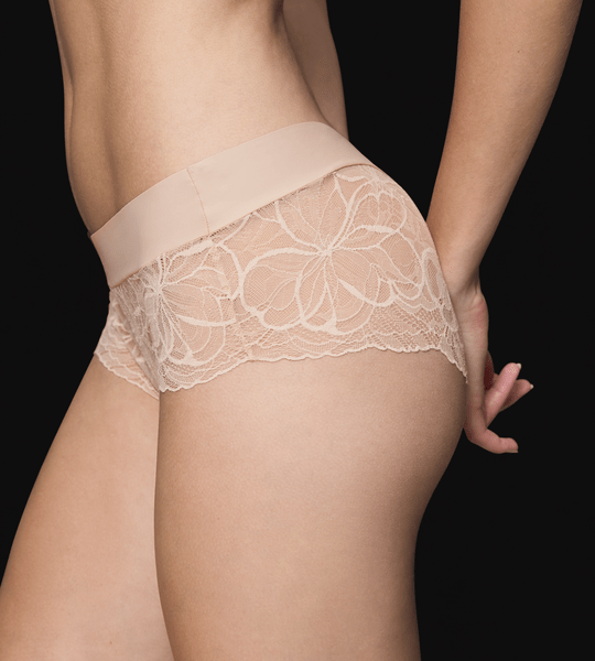 Modellen bærer Triumph Body Make-Up Illution Lace NZ Pudder-hipster set fra siden og bagfra på sort baggrund.