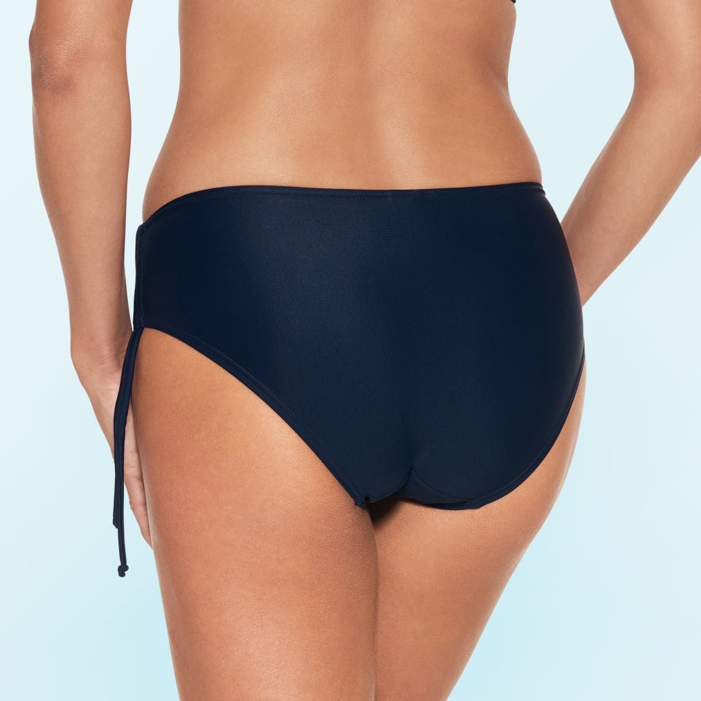 Model på Wiki – Midnight Mørkeblå bikinitrusser set bagfra på en lyseblå baggrund.