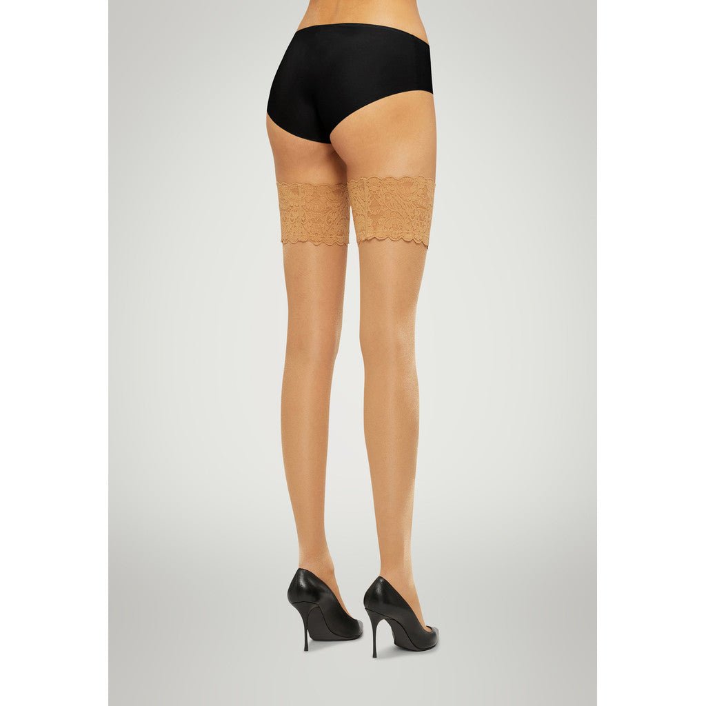 En kvinde i sort undertøj og Wolford Satin Touch 20 Gobi-strømper, set bagfra.