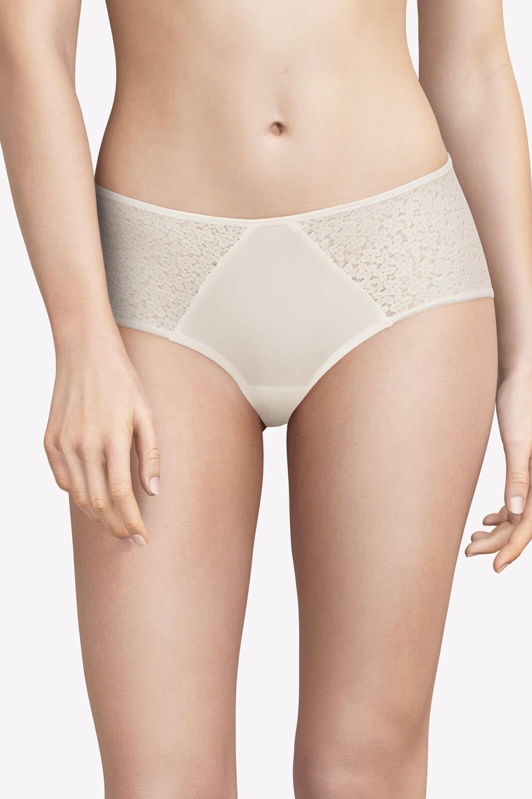 En kvinde viser Chantelle EasyFeel Norah NL Hud beige blonde-hipstertrusser frem foran en ensfarvet baggrund.