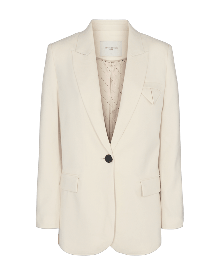 Copenhagen Muse Tailor Off-white blazer med skrå revers, lommer og et diskret mønstret for.